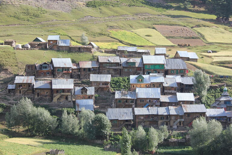 Wooden village houses with tin roofs among terraced fields in Gurez Valley